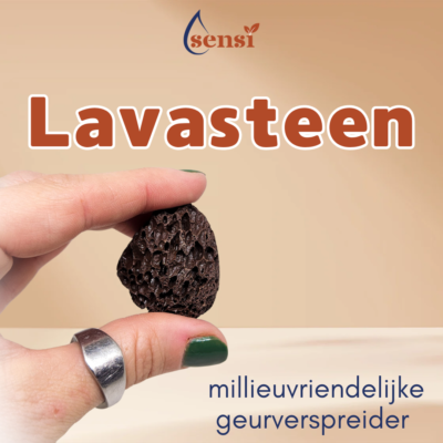 Een hand die tussen twee vingers een stukje lavasteen vast heeft. Lavasteen wordt gebruikt om druppels essentiële olie op de druppelen zodat de ruimte lekker gaat ruiken.